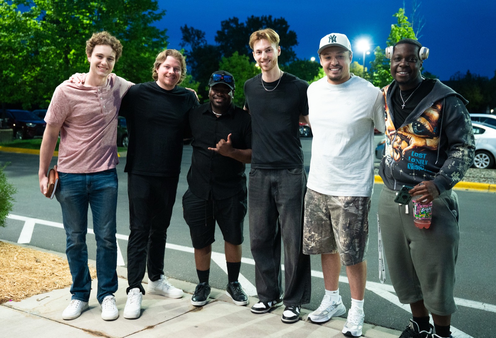 A group of students together outside the campus in the evening