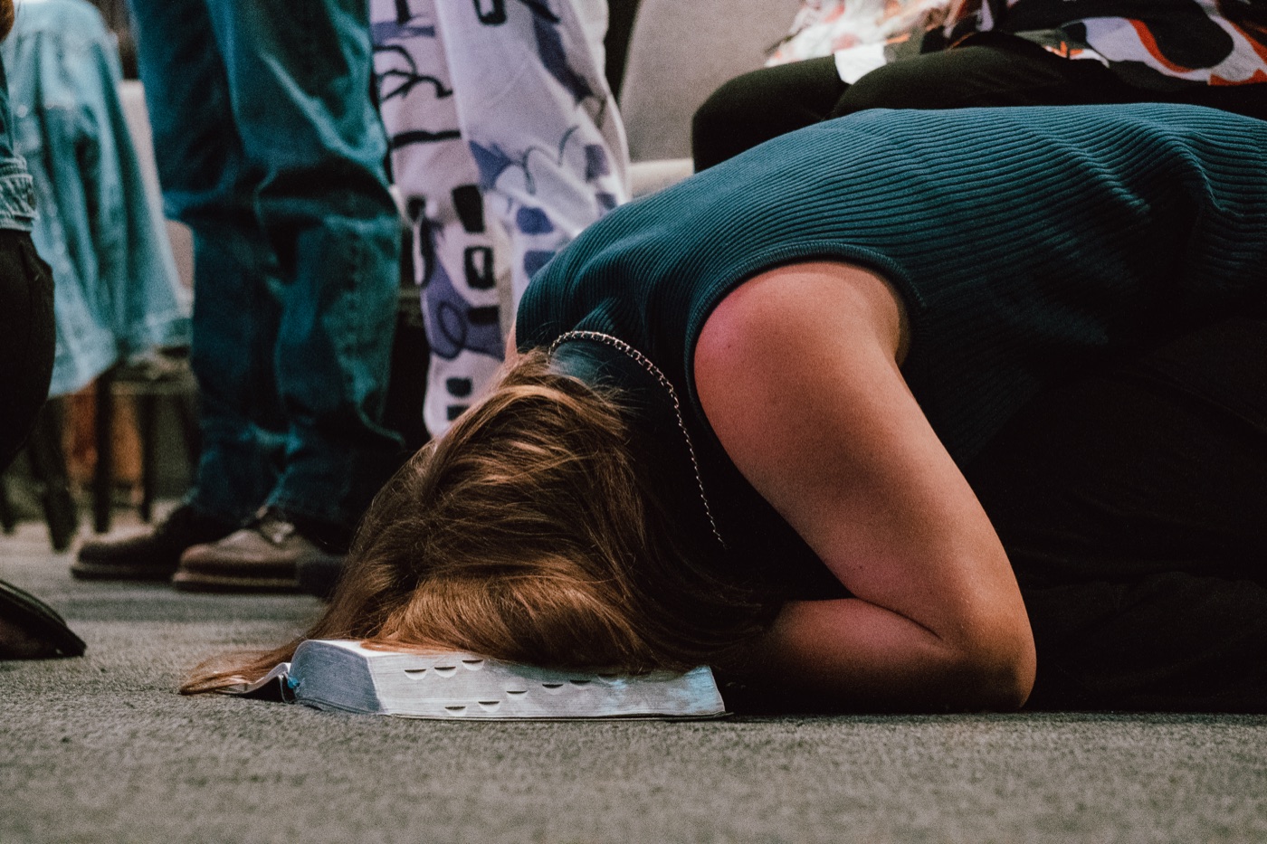 A student bowed in worship over an open Bible
